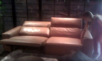 Leather sofa with one section in reclined position