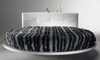 Head on view of Luxury modern  round bed  by Reflex made in Italy with Black and Gray Blanket