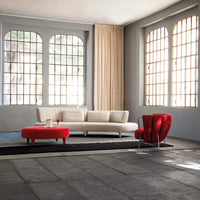 Delta Sagomato sofa with red foot stools nearby