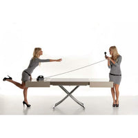 Two Italian women adjust the size of a coffee table
