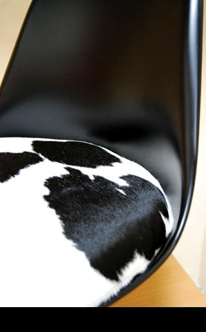 Close up view of cow print seat on black modern dining chair made in Italy