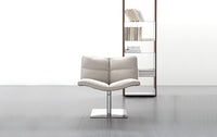 Wave Soft Chair in white leather with bookshelf behind it
